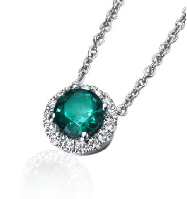 Colgante de  oro blanco con Esmeralda y orla de Diamantes